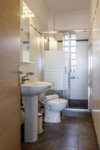 a bathroom with a sink and a toilet and a shower at Christina's Apartment in Tolo +67 photos