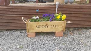 a wooden crate with a sign that reads sunny days at Achmelvich View self catering in Lochinver