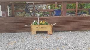 a wooden crate with a potted plant in front of a building at Achmelvich View self catering in Lochinver