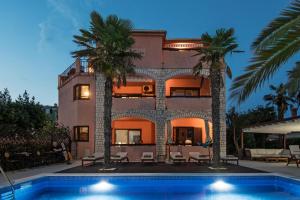 a house with a swimming pool in front of a building at Bed & Breakfast Anita in Medulin