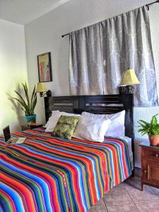 a bedroom with a bed with a colorful striped blanket at Seaside Inn Roatan in West Bay