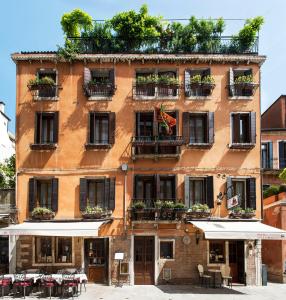 een oranje gebouw met planten op de balkons bij Hotel Agli Alboretti in Venetië