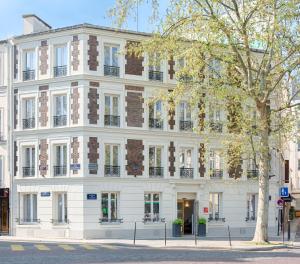 a white building with a tree in front of it at Hôtel Korner Etoile in Paris