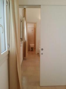 a hallway with a white door leading to a kitchen at Antica Masseria Ficazzana - Tenuta in Marina di Pescoluse