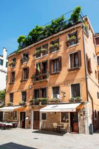 un grande edificio arancione con tavoli e sedie di fronte di Hotel Agli Alboretti a Venezia