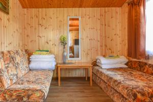 a living room with two couches and a table at Sodyba Džiugutis in Šventoji