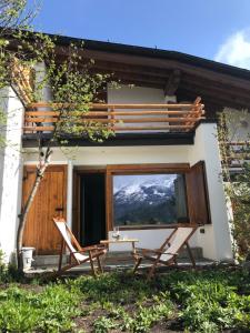 a pair of chairs and a table in front of a house at Comfort and sunshine in Celerina Chesa Prasura in Celerina