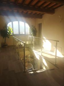 a staircase in a room with a window and a glass railing at Alba Morus Bed e Breakfast sentiti a casa nel cuore della Toscana in Arezzo
