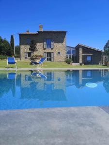 a swimming pool with two chairs and a house at Alba Morus Bed e Breakfast sentiti a casa nel cuore della Toscana in Arezzo