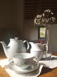 una mesa con una tetera y tazas y un jarrón en Alba Morus Bed e Breakfast sentiti a casa nel cuore della Toscana en Arezzo