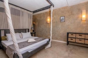 a bedroom with a bed with a hanging bed frame at The Lawford in Malindi