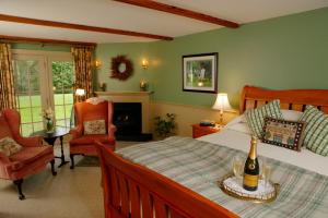 a bedroom with a bed with a bottle of champagne at Captain's House Inn in Chatham