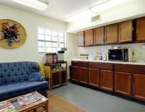 a living room with a blue couch and a kitchen at Country Side Inn in Tyler