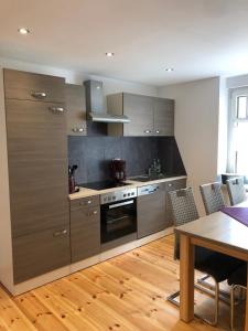 a kitchen with stainless steel appliances and a table at Ferienwohnung Alte Molkerei in Bad Sulza