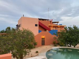 a house with a swimming pool in front of a building at Hotel Boutique Las Terrazas in Pescadero