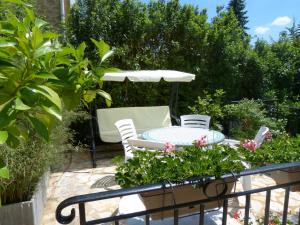 eine Terrasse mit einem Tisch und Stühlen im Garten in der Unterkunft Maison Pierre D'Or in Sarlat-la-Canéda