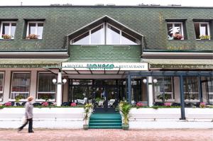 un homme marchant devant un bâtiment dans l'établissement Hotel Monaco, à Náměšť nad Oslavou