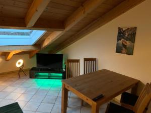 uma sala de estar com uma mesa de madeira e uma televisão em Ferienwohnung Juliane em Holzkirchen