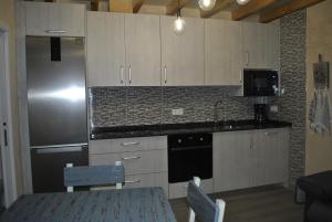 a kitchen with white cabinets and a stainless steel refrigerator at CASA NATALIA, San Vitero in San Vitero