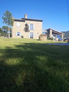 un gran campo de césped con una casa en el fondo en Alba Morus Bed e Breakfast sentiti a casa nel cuore della Toscana, en Arezzo
