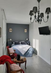 a bedroom with a bed and a table and chairs at Hôtel restaurant du Commerce in Poulainville