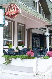 a hotel with tables and chairs in front of a restaurant at Hotel Monaco in Náměšť nad Oslavou