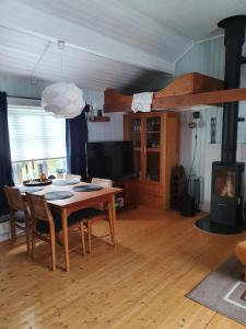 a dining room with a table and a fireplace at Sjøhaug Rorbu in Moskenes