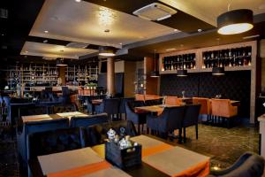 a restaurant with tables and chairs and wine bottles at Hotel Meduza in Senj