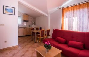 a living room with a red couch and a table at Apartmani Nikoletić in Klek