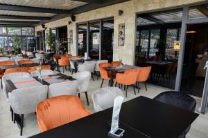 a restaurant with tables and chairs and windows at Hotel Meduza in Senj