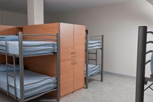 ムシアにあるAlbergue Bela Muxiaの二段ベッドとクローゼットが備わる二段ベッド付きの客室です。