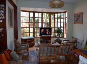 a living room with a tv in a room with windows at Backpacker's Hostel Iquique in Iquique