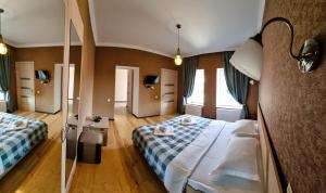 una camera d'albergo con due letti e uno specchio di Varga Kvareli a Kvareli