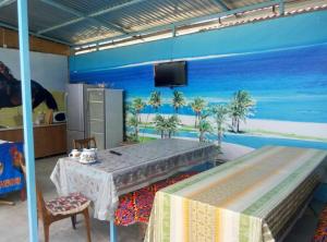 a room with a table and a mural of the beach at Отдых в Капшагае! in Kapchagay