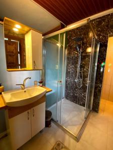 a bathroom with a shower and a sink and a showerspective at Kaf Dagi Konak Hotel in Rize