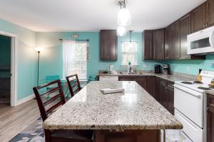a kitchen with wooden cabinets and a table with chairs at Turtles Nest in Dauphin Island