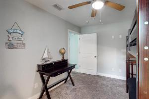a room with a piano and a ceiling fan at Turtles Nest in Dauphin Island