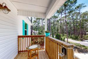 a porch with a table and a chair at Turtles Nest in Dauphin Island