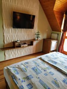 a bedroom with a bed and a flat screen tv at Bodó Ház in Gyenesdiás