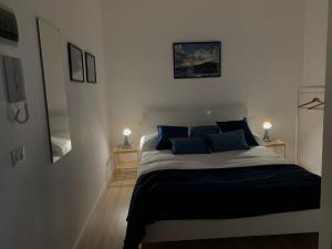 a bedroom with a large bed with blue pillows at Casa Vacanze Caramagna in Aci Castello