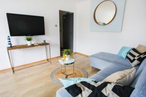 a living room with a blue couch and a tv at Apartament Błękitno na Białym in Władysławowo