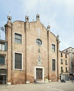 un grand bâtiment en briques avec une horloge. dans l'établissement Ca al Campanile, à Venise