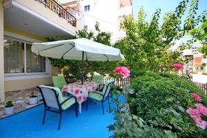 a table with chairs and an umbrella on a patio at KIPRIANOS - STUDIOS in Loutra Edipsou