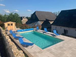 a swimming pool with blue chairs and a swimming pool at Gîte La feuille d'Acanthe in Bucilly