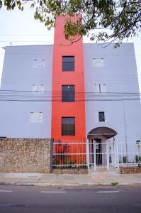 a building with an orange stripe on the side of it at Central Park Hotel Residence in São Carlos