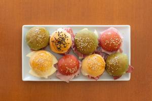 a plate of different types of donuts on a table at Hotel Posta in Cecina