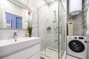 a bathroom with a sink and a washing machine at Комфортные апартаменты 36 жемчужина in Odesa +51 photos