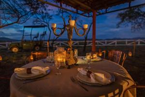 a table with plates and glasses and a chandelier at Rancho Humo Estancia in Puerto Humo
