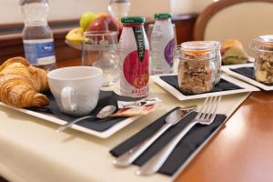 a table with two plates of food and utensils at Hotel Posta in Cecina