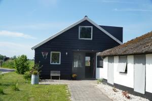 a black and white house with a porch at Groepsverblijf "De Klosse" in Wanneperveen
